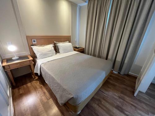 a small bedroom with a bed and two night stands at Hotel Jardins Univer Pamplona com garage coz 2709 in Sao Paulo