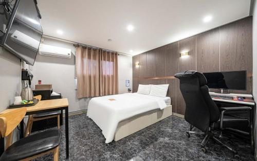 a hotel room with a bed and a desk and a computer at On & Off Hotel in Incheon