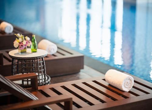 una mesa con un jarrón de flores junto a una piscina en Wyndham Grand Shenzhen Guangming, en Shenzhen