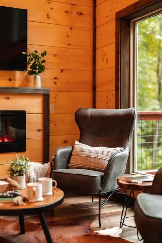 a living room with a chair and a fireplace at New Cozy Mountain Chalet Hot Tub Near Downtown in Gatlinburg