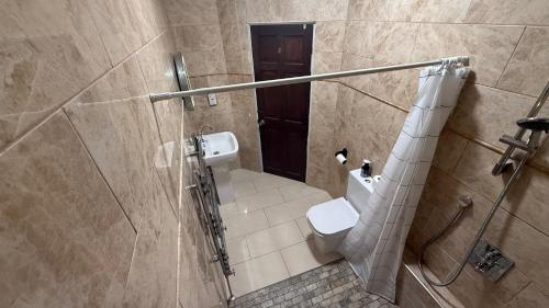 Un pequeño baño con inodoro y ducha. en Pat Signature STAYS, en Kingsthorpe