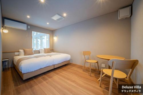 a bedroom with a bed and a table and chairs at Rusutsu Hills CENTRO in Rusutsu