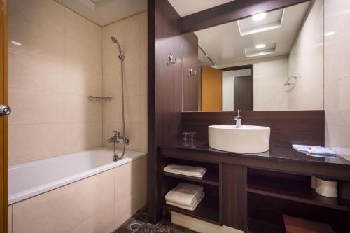 La salle de bains est pourvue d'un lavabo, d'une baignoire et d'un miroir. dans l'établissement Twinstar Hotel, à Taichung