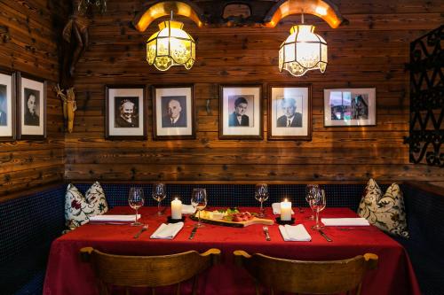 a dining room with a red table and pictures on the wall at Traditionsgasthof Weißbacher in Auffach