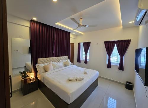une chambre avec un lit et une télévision dans l'établissement Broadway Inn, à Mysore