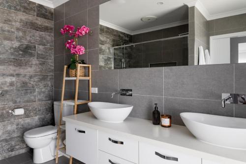 une salle de bain avec deux lavabos et un WC dans l'établissement Surfrider Hideaway - steps to beach, à Mudjimba