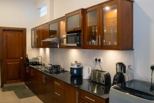 a kitchen with wooden cabinets and a counter top at Moonlit Luxury Apartments in Piliyandala
