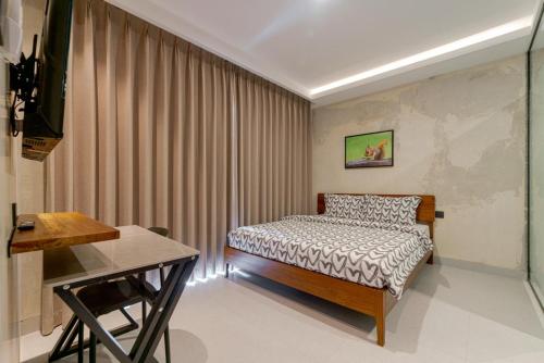 a bedroom with a bed and a desk in it at Palm Stay Residence in Nagoya