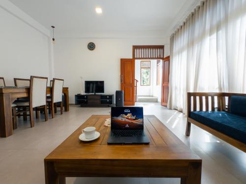 a laptop on a wooden table in a living room at Moonlit Luxury Apartments in Piliyandala