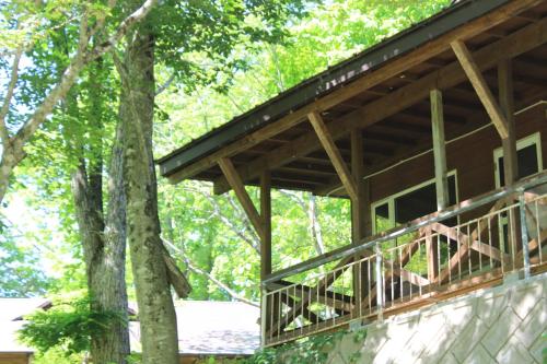 a building with a porch with trees in the background at WEND URABANDAI -the private villa- in Kitashiobara