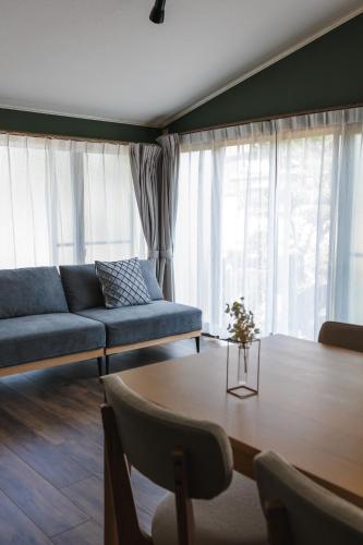 a living room with a couch and a table at 古民家の宿 Yamotas 馬籠 in Nakatsugawa