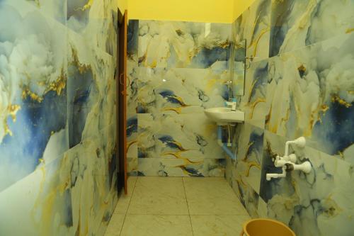 une salle de bains avec un tableau de nuages sur le mur dans l'établissement Seawave Beach Resort, à Bahūr