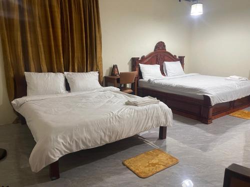 a bedroom with two beds with white sheets at Joeshomestaysiemreap in Phumĭ Bœ̆ng (1)