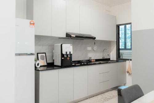 a kitchen with white cabinets and a sink at Aston Acacia Residence Bukit Mertajam in Bukit Mertajam