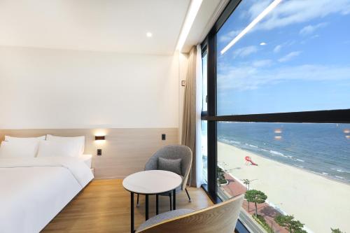 a hotel room with a bed and a view of the ocean at Pohang Hound Hotel Songdo Beach in Samgong