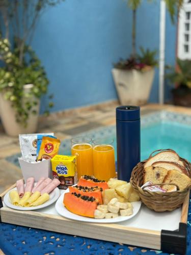 ein Tablett mit Essen und Getränken auf einem Tisch neben einem Pool in der Unterkunft Luah Buziana in Búzios