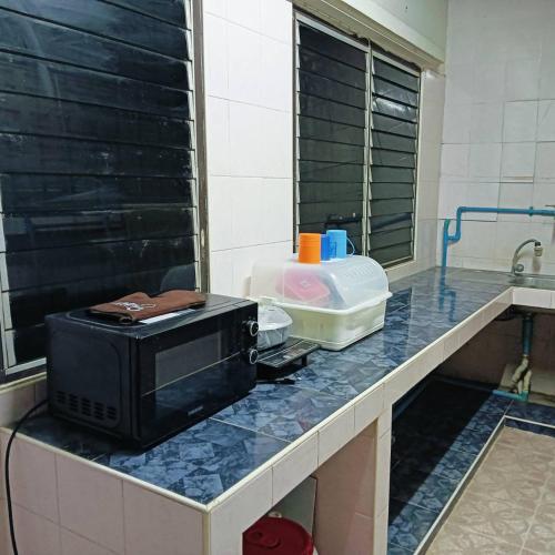a microwave sitting on a counter in a kitchen at เจแปน บ้านพักรายวัน in Pak Chong