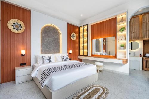 a bedroom with a large white bed and wooden walls at Casa Santisya 4 by Orivista , 4min beach in Mengwi