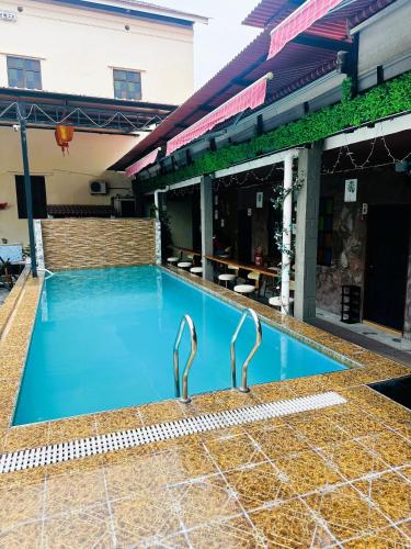 a swimming pool with two metal faucets next to a building at The Century Hostel George Town 乔治市世纪青旅 in George Town