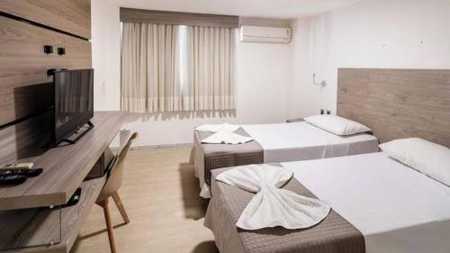 a hotel room with two beds and a flat screen tv at Roma - pyramids view in Cairo