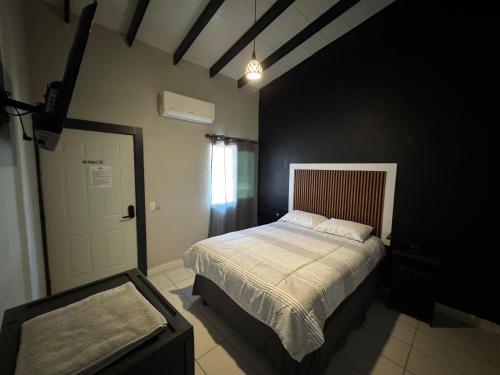 a bedroom with a bed and a black wall at RC LUX Hotel in Choluteca