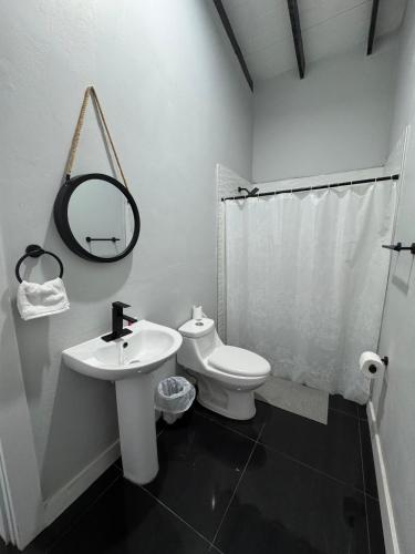 a white bathroom with a sink and a toilet at RC LUX Hotel in Choluteca