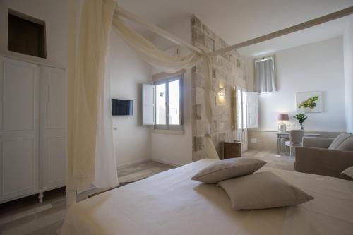 ガラティーナにあるLi Pappi Antico Casaleの白いベッドルーム(枕付きのベッド付)