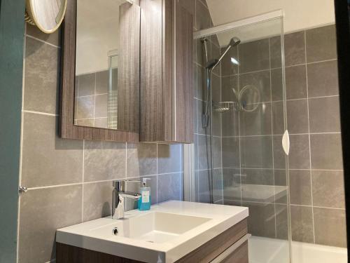 une salle de bain avec un lavabo blanc et une douche dans l'établissement 6 pers - Modern holiday home with garden, close the Lauwersmeer, à Oostmahorn