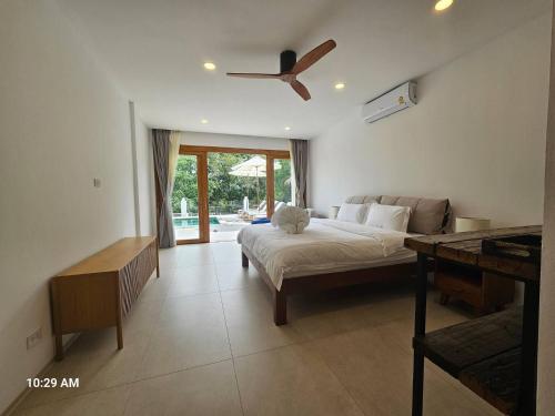 Un dormitorio con una cama y un ventilador de techo. en 8Br monkey villa room 203, en Chaweng Noi Beach
