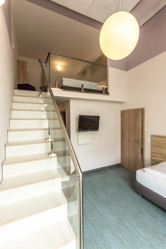 a staircase in a room with a bed and a bed at Schumanns Garten in Weißenfels