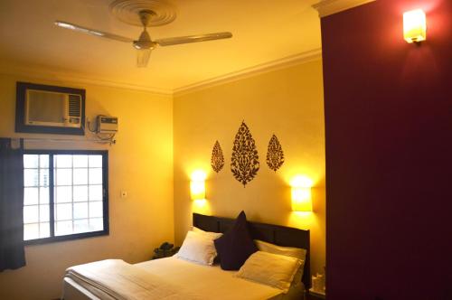 a bedroom with a bed with yellow walls and a window at La Casa in Haridwār