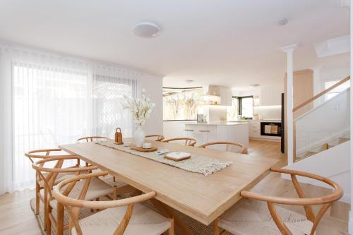 a kitchen and dining room with a wooden table and chairs at Scarborough Family Beachside Retreat - Walk to beach in Perth