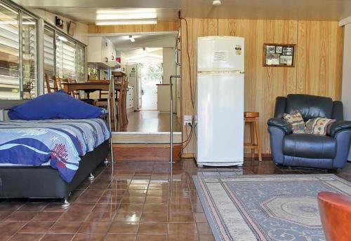 a room with a refrigerator and a chair and a bed at Anchorage in Amity Point
