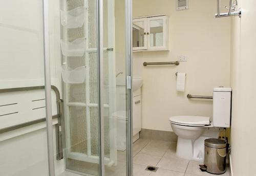 a bathroom with a toilet and a glass shower at Anchorage in Amity Point