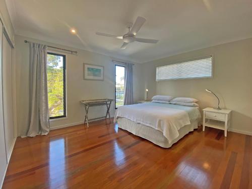 a bedroom with a bed and a ceiling fan at Annies House in Amity Point