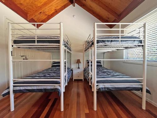 two bunk beds in a room with wooden floors at Flinders Breeze in Amity Point