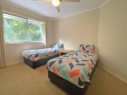 Un dormitorio con una cama y una silla y una ventana. en Amity Seaside, en Amity Point