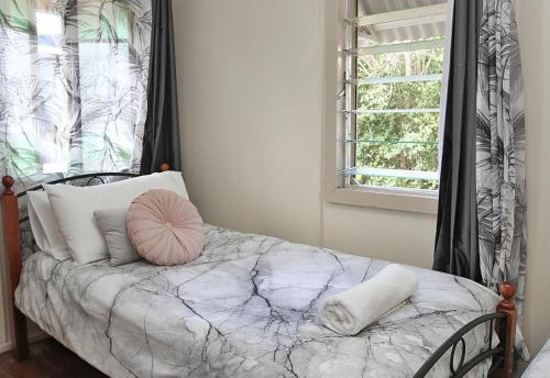 1 cama con almohadas en una habitación con ventana en Berrimilla, en Amity Point