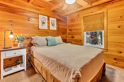 a bedroom with a bed in a wooden room at Cozy Walnut Mountain Cabin with Hot Tub & Views in Ellijay