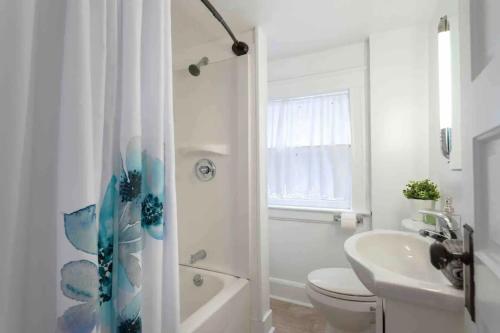 a white bathroom with a toilet and a sink at Westport Plaza Stay 2BR Cozy Escape in Kansas City