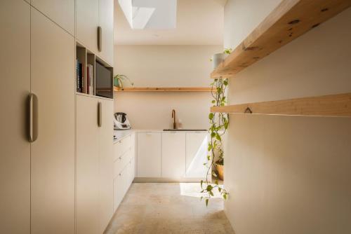 a kitchen with white cabinets and ivy on the wall at Wave Break in North Creek