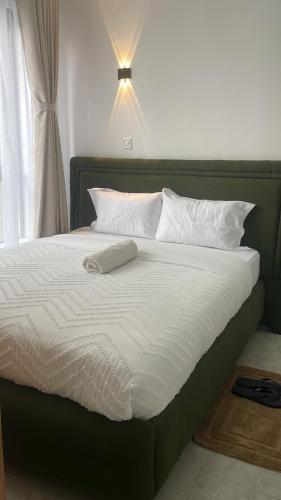 a large bed with a green headboard and white pillows at Shamzluxury2 in Nairobi