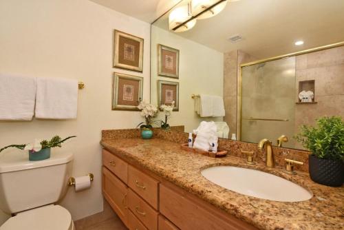 Un baño con lavabo, inodoro y espejo. en Kahana Reef 117 · KR 117 Renovated OceanFront 1BD w Ocean Views, en Kahana