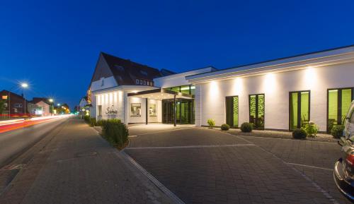 an empty street in front of a building at night at Hotel & Restaurant Schönau in Peine