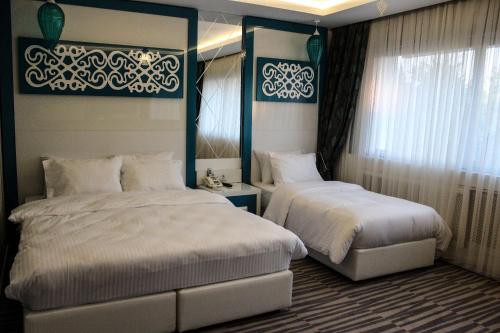 a bedroom with two beds and a window at Grand Bursa Hotel in Bursa