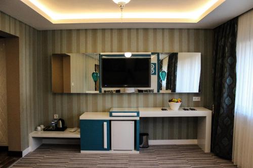 a room with a desk with a tv on a wall at Grand Bursa Hotel in Bursa