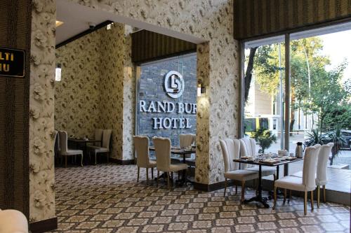a restaurant with tables and chairs and a sign on the wall at Grand Bursa Hotel in Bursa