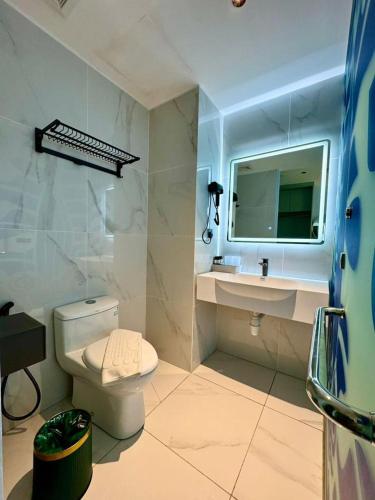 a bathroom with a toilet and a sink and a mirror at Wing Tat Grand Hotel in Semporna