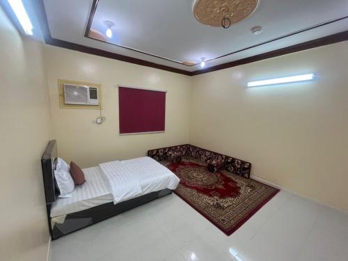 a bedroom with a bed and a tv on the ceiling at شقق لافندر in Sūq ath Thalut