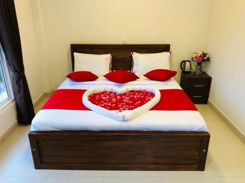 a bed with red pillows and a heart shapedvertisement sidx sidx sidx at Little Heaven Villa in Ambawela